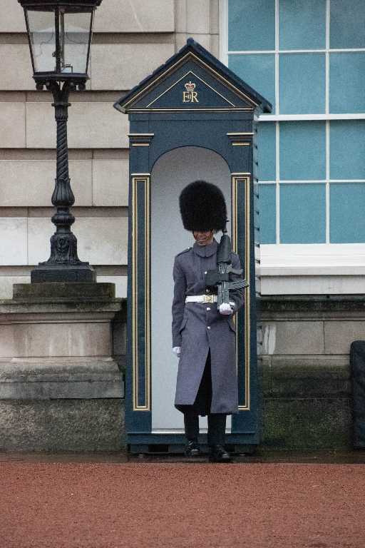 man in blue coat standing near white wooden door